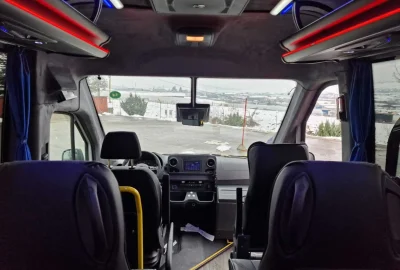 Interior view of the driver's area in a premium tourist bus with a scenic snowy backdrop.