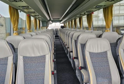 Interior of a VanHool bus with comfortable seating and spacious design.