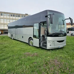 Exterior view of a VanHool bus parked on a grassy field, showcasing its elegant design.
