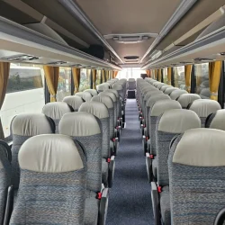 Interior view of a VanHool bus showing comfortable seating arrangement and spacious design.