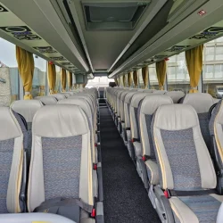 Interior of a VanHool bus with comfortable seating and spacious design.