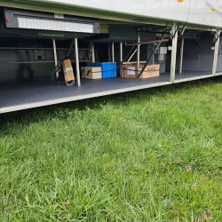 Spacious luggage compartment of a VanHool bus with organized storage space.